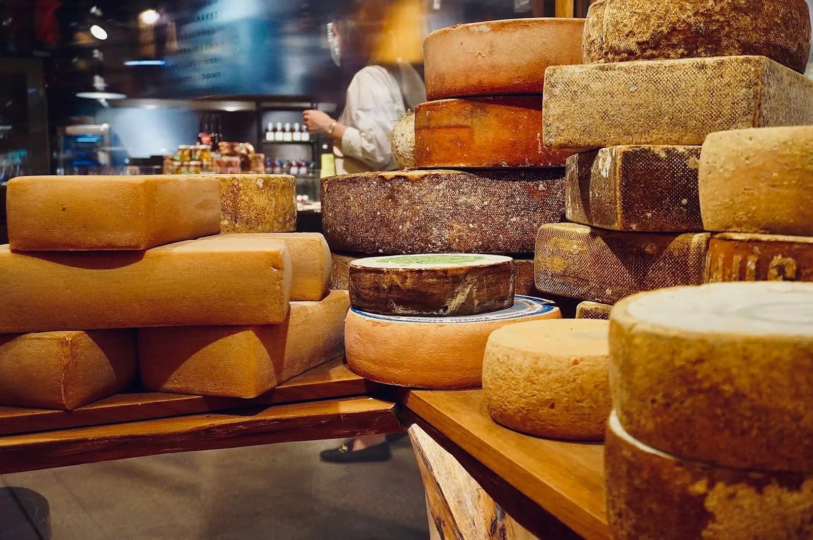 Wheels of cheese stacked on a shop’s shelves