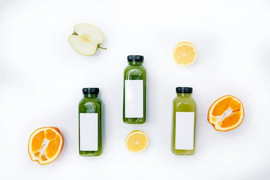 Three bottles of green juice beside oranges and lemons