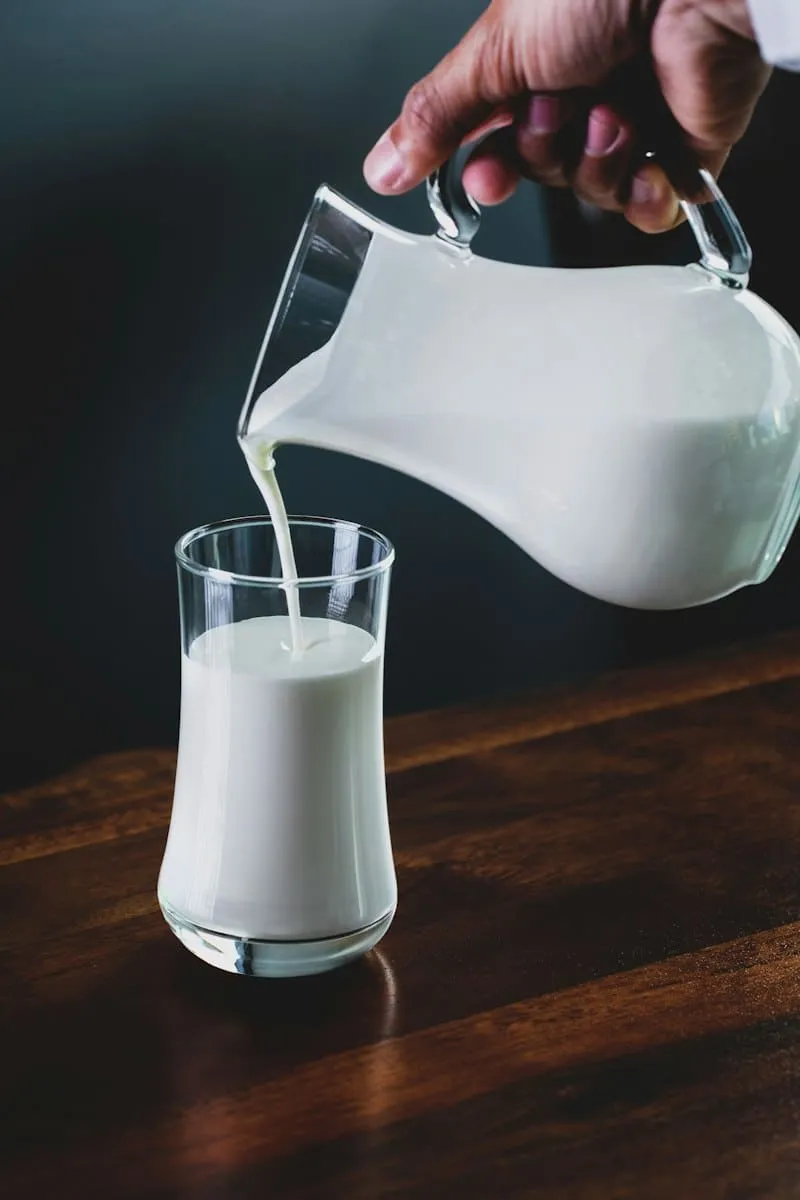 Milk poured from a jug into a glass