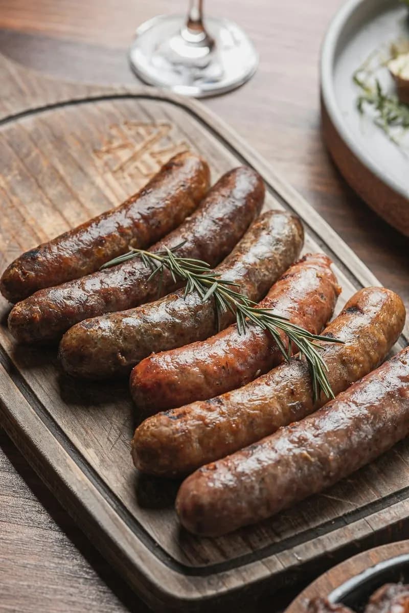 Grilled sausages with rosemary on a wooden board